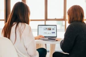 Two people talking while looking at the screen